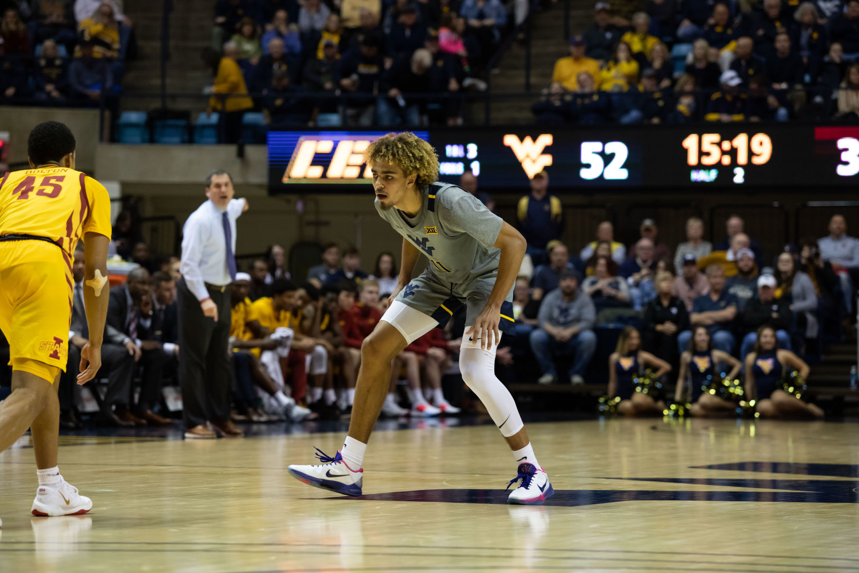West Virginia's Emmitt Matthews Jr. defends as Iowa State's Rasir Bolton drives up the court.